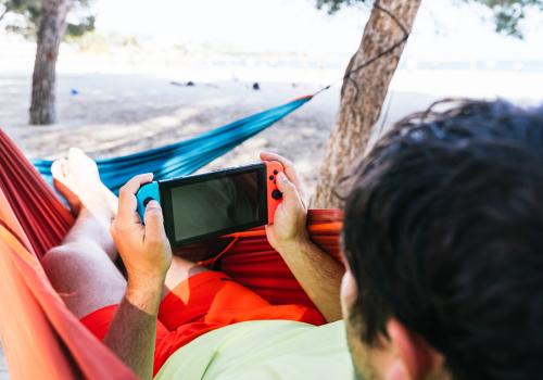Persona jugando en la consola de Nintendo Switch sobre una hamaca